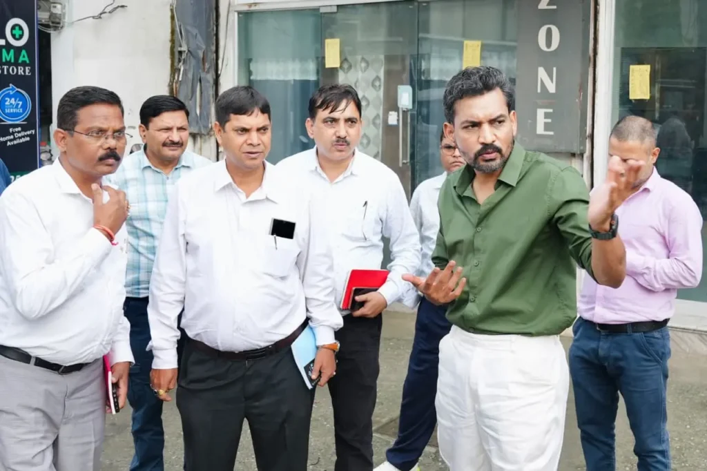 देहरादून में शिमला बाईपास रोड पर गड्ढों का निरीक्षण करते जिलाधिकारी डॉ आशीष चौहान